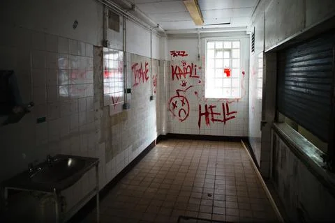 Prison hall with Hell writing on the wall Stock Photos