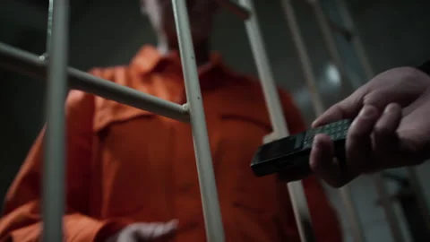 Prison Inmate Receiving Cell Phone from Corrupt Guard Stock Footage 263254404