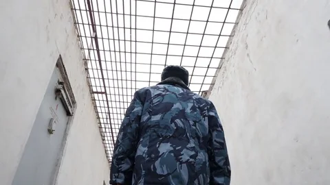 Prison officer walking in inter yard in russian penitentiary colony, jail Stock Footage 81582148