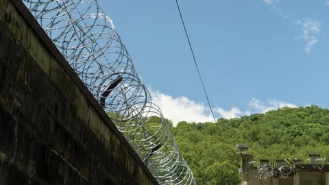 Prison or Jail Wall and Razor Wire Time Lapse Stock-Footage 107678968