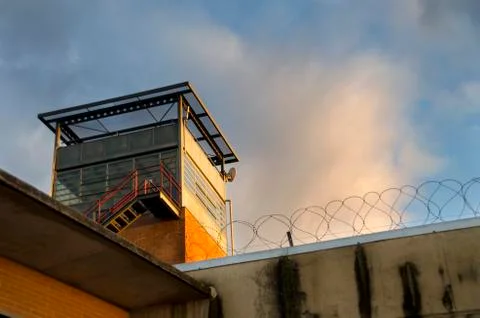 Prison tower, wall and barbed wire Stock Photos