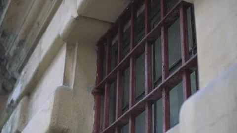 Prison window behind red bars from street. Stock Footage 201311715