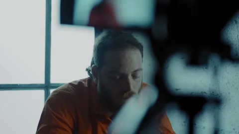 Prisoner being interrogated in a dark room Stock Footage 275028579