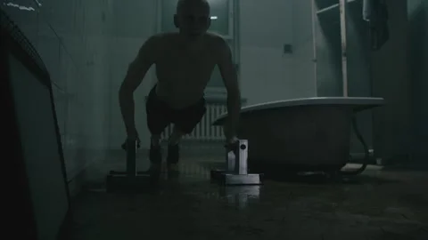 A prisoner doing pushups in jail next to a bath tub Video stock 259677263