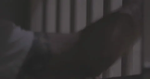 Prisoner Gripping and Reaching through Bars 4K Stock Footage 145998359