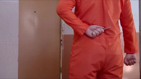 The prisoner hides behind a sharpener to attack the guard who entered the cell Stock Footage 167068150