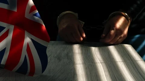 Prisoner in interrogation room with British Union Jack flag Stock Footage 317989966