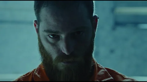 Prisoner looking at the camera in a small dark room Stock Footage 275084897