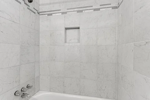 Pristine Bathroom With White Tiled Shower And Built-In Shelving For Storage Stock Photos