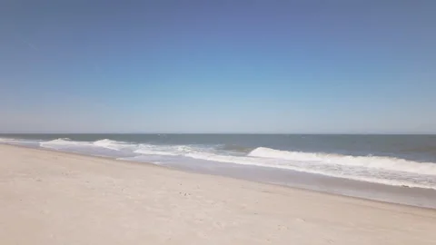 Pristine beach and slow moving waves approach the coastal shoreline in hypnotic Stockbeeldmateriaal 337180777