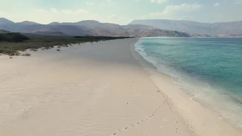 Pristine beach beside turquoise sea and rugged cliffs, Socotra siland Stock Footage 322019911