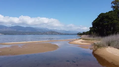 A pristine beach with scattered puddles reflects the clear sky Stock Footage 253542004