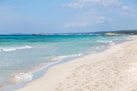 Pristine beach with turquoise ocean water under blue sky Stock Photos