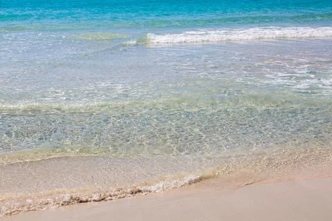 Pristine beach with turquoise ocean water under blue sky Stock Photos