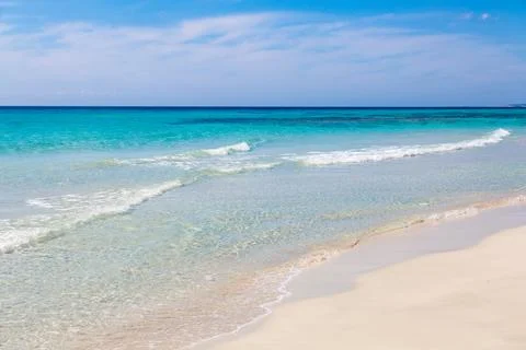 Pristine beach with turquoise ocean water under blue sky Stock Photos