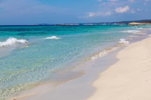 Pristine beach with turquoise ocean water under blue sky Stock Photos
