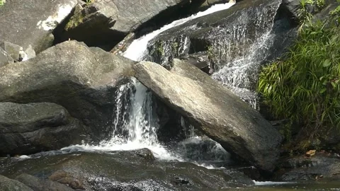 A pristine flowing water on rocks in a waterfall in Malaysia Video stock 155591698