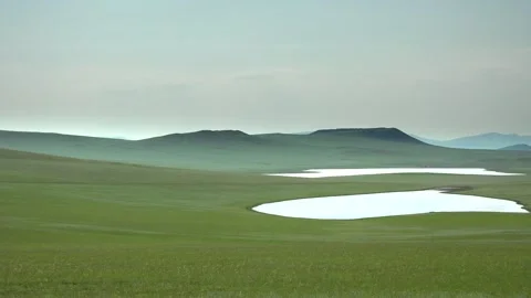 Pristine lake curves through empty Mongolia steppe - Green Plain and Wide Grass Stock Footage 339719529