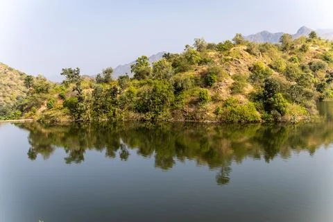 Pristine lake with mountain forest reflection at day from different angle 库存照片
