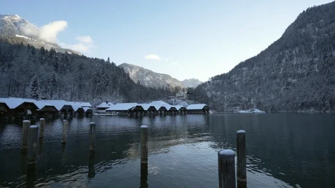 Pristine mountain lake in Bavaria in winter with boat houses and clouds Stock Footage 120984939