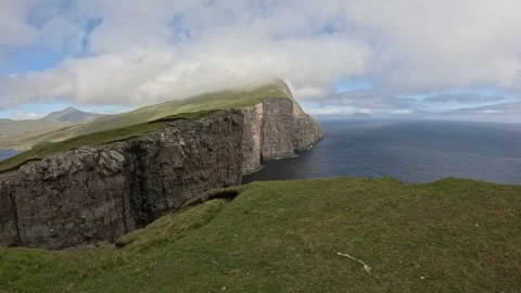 Pristine Nordic landscape of massive volcanic rock cliff under cloudy sky Stock Footage 337463852