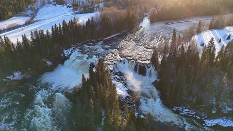 Pristine Norwegian Winter River Framed by Snowy Forests and Golden Sunlight Stock Photos
