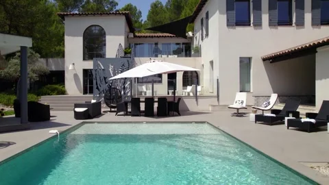 The pristine pool takes center stage in the scene, reflecting the clear Stock Footage 243960354