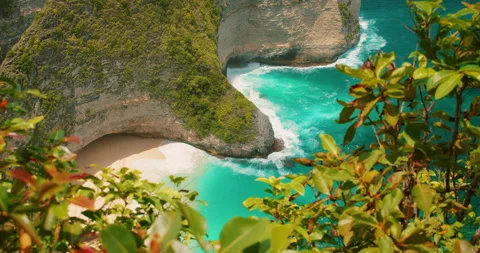 Pristine sand and turquoise ocean waves at Kelingking Beach Nusa Penida coastal Stock Footage 344214162