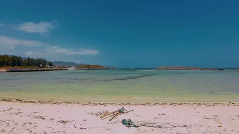 Pristine Sand Beach and Shallow Turquoise Lagoon with Distant Islets Stock Footage 337583166