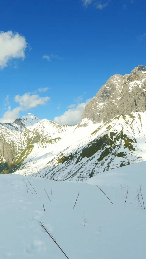 Pristine Snow Tracks Through Mountain Valleys and Rugged Peaks near Jochgern Stock Footage 308296071