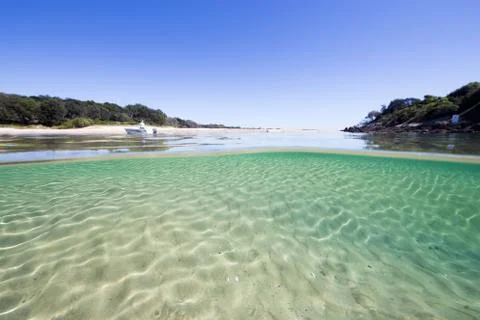 Pristine split underwater shot of a vibrant, turquoise beach scene Stock Photos