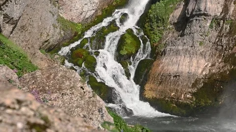 Pristine waterfall flowing downstream in Alps mountain Stock Footage 137154344