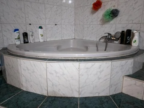 A pristine, well-designed bathroom features a corner bathtub, offering a se.. Stock Photos