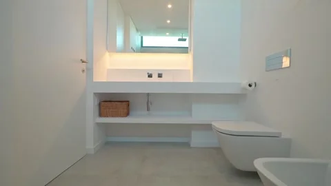 Pristine white bathroom showcasing sleek floating vanity, toilet, bidet, and Stock Footage 320893266