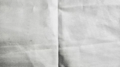 Pristine white fabric texture reveals intricate wrinkle with soft shadow in m Stock Photos