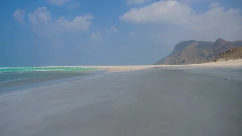 Pristine White Sand Beach with Turquoise Waters and Dramatic Coastal Mountains Stock Footage 336984013