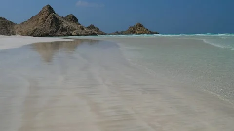 Pristine White Sand Beach with Turquoise Waters and Dramatic Coastal Mountains Stock Footage 336984465