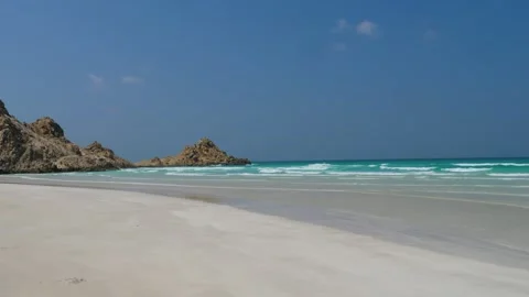 Pristine White Sand Beach with Turquoise Waters and Dramatic Coastal Mountains Video stock 336984477