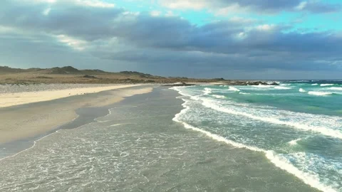 Pristine White Sand Beach with Turquoise Waters and Dramatic Coastal Mountains 库存影片 337955627