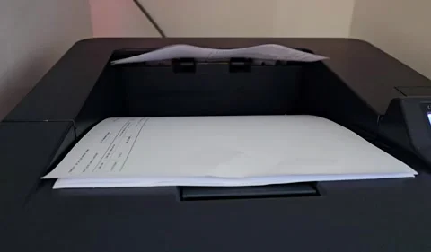 A pristine white sheet emerges from a sleek dark printer. Stock Footage 311767060
