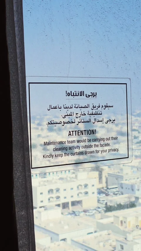 A privacy caution notice displayed in Arabic and English on a glass window. Vidéo 347889346