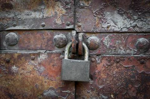 Privacy concept background: old rusty metal door closed with a massive lock Stock Photos