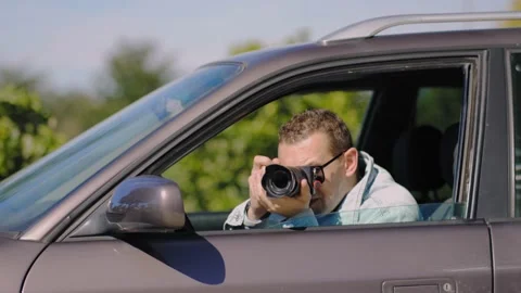Private detective with camera spying near car outdoors Stockbeeldmateriaal 237239491