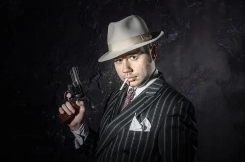 Private detective in hatwith cigarette. Agent looks like mafiosi stay side to Stock Photos