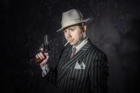 Private detective in hatwith cigarette. Agent looks like mafiosi stay side to Stock Photos