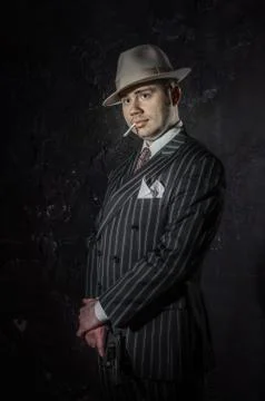 Private detective in hatwith cigarette. Agent looks like mafiosi stay side to Stock Photos