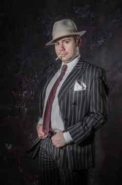 Private detective in hatwith cigarette. Agent looks like mafiosi stay side to Stock Photos