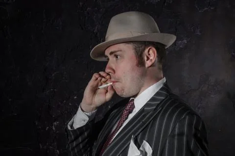 Private detective in hatwith cigarette. Agent looks like mafiosi stay side to Stock Photos