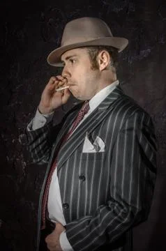Private detective in hatwith cigarette. Agent looks like mafiosi stay side to Stock Photos