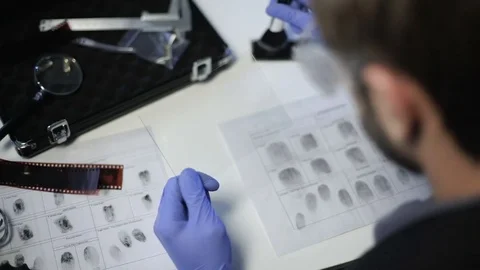 Private detective using powder and brush to lift fingerprint from piece of glass 스톡 동영상 85081464